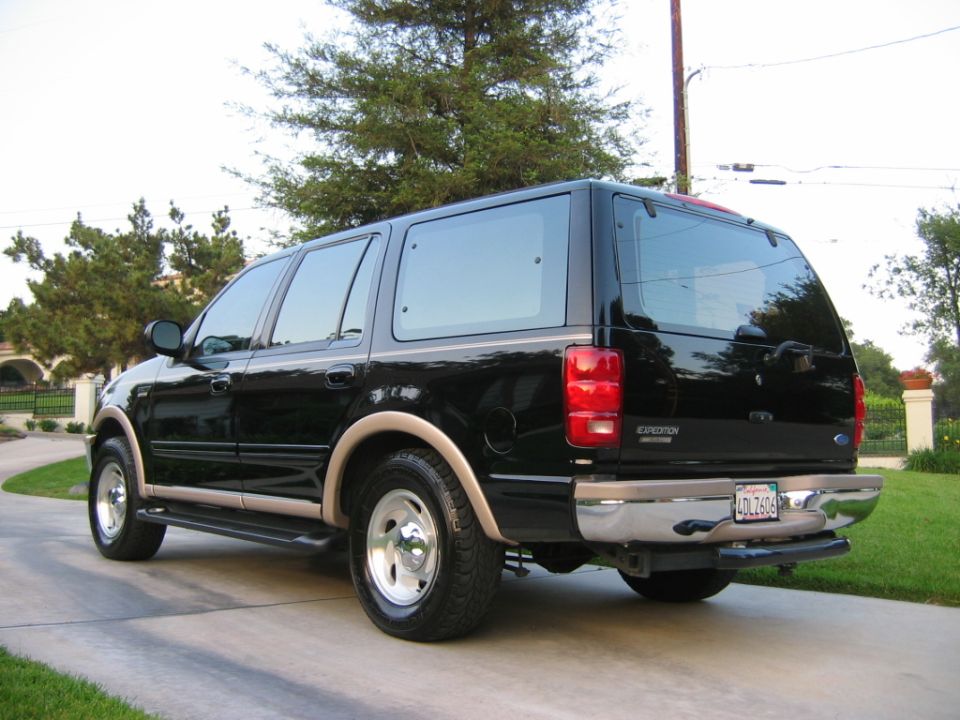 Black Ford Expedition SUV rear three-quarter view on driveway