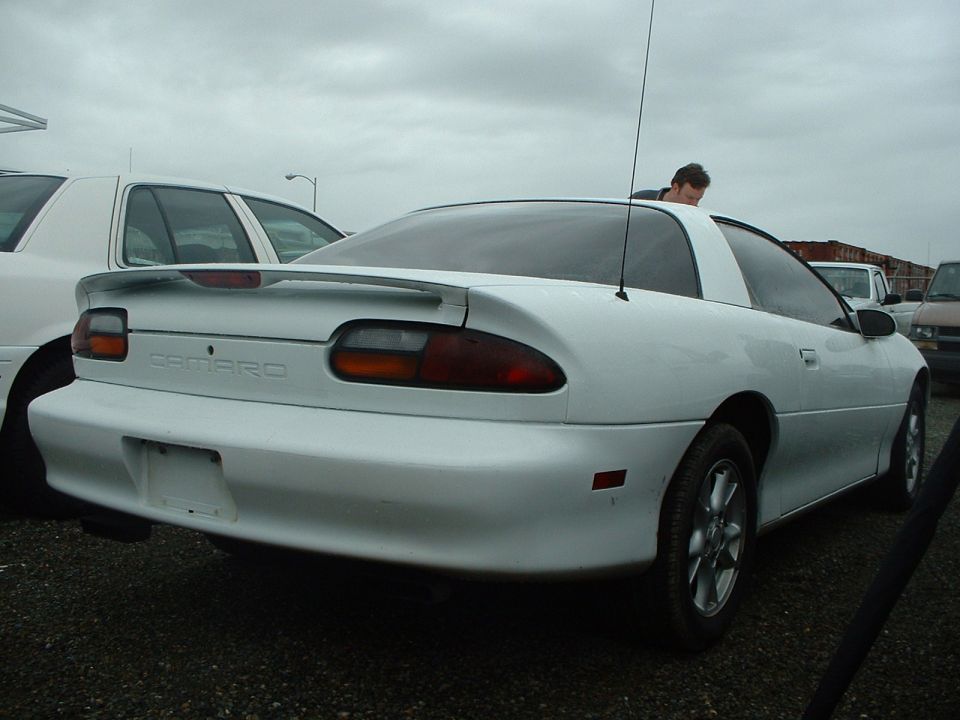 White Chevrolet Camaro coupe, rear view, with a spoiler and a visible 'Camaro' badge
