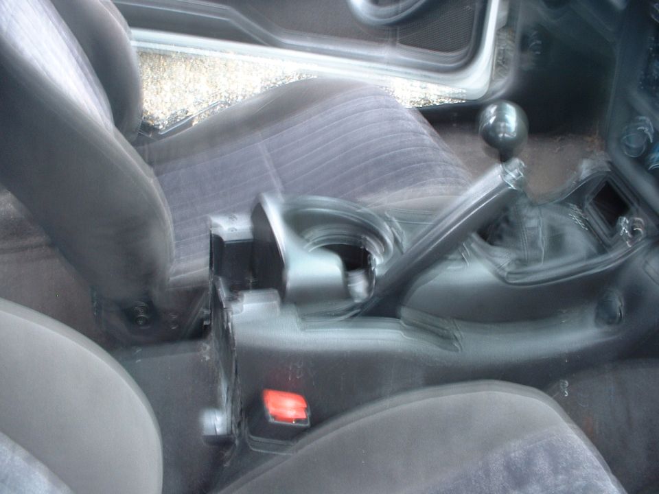 Interior view of a car's center console showing the gear shifter and part of the seats