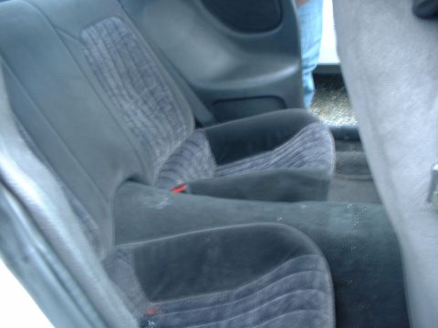 2000 Ford Crown Victoria - The interior of a vehicle is shown, focusing on the rear seating area with its distinctive fabric pattern.