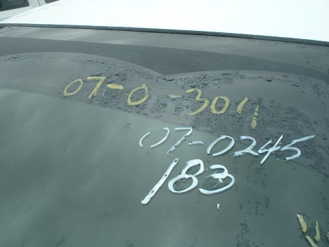 2000 Ford Crown Victoria - Handwritten numbers are visible on the dusty windshield of a vehicle.