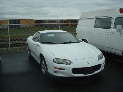 2000 Ford Crown Victoria - Front view of a white Chevrolet Camaro, parked outdoors under an overcast sky.