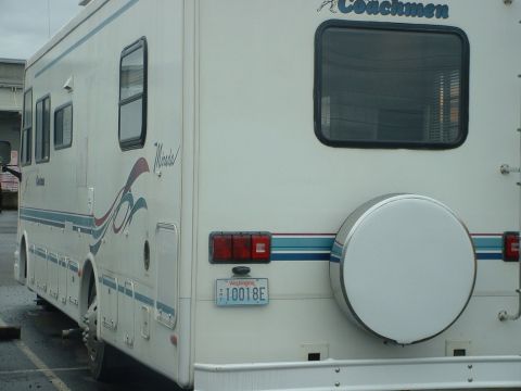 2000 Ford Crown Victoria - Rear view of a white RV, a spare tire cover and a Washington license plate.