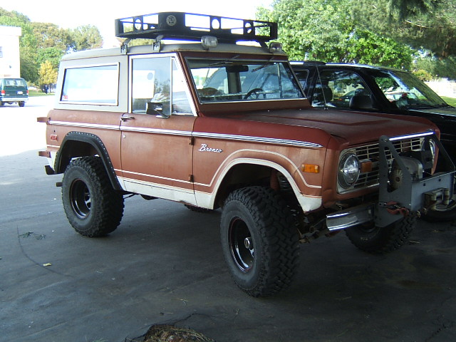 Red and white Ford Bronco with roof rack and winch