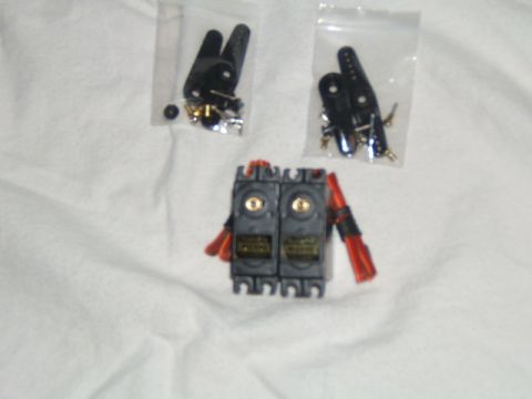 1988 Ford Bronco - RC servo motors and associated parts are laid out on a white surface.