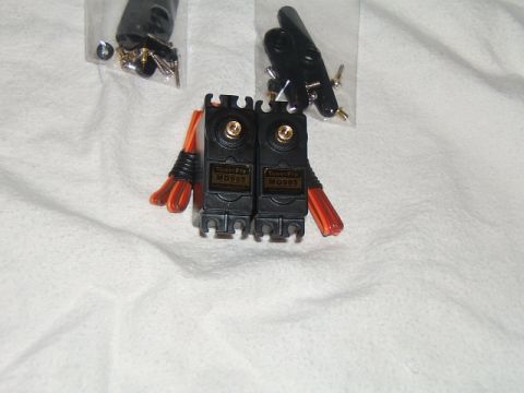 1988 Ford Bronco - Two servo motors and associated hardware are laid out on a white cloth surface.