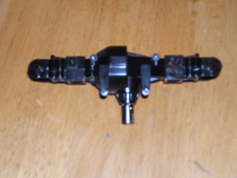 1988 Ford Bronco - Close-up of a black differential axle assembly, likely for an RC vehicle, against a wooden background.