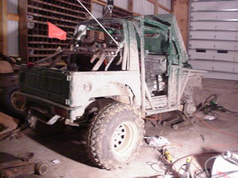 1992 Ford Bronco - This heavily modified off-road vehicle appears to be undergoing significant construction or customization in a workshop setting.