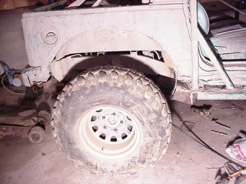 1992 Ford Bronco - Close-up view of a vehicle's rear wheel and fender, suggesting it is in a workshop or garage.
