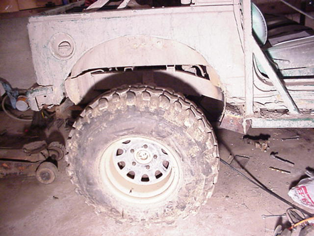 Rear wheel and fender of a vehicle, possibly undergoing repair. A large tire is visible