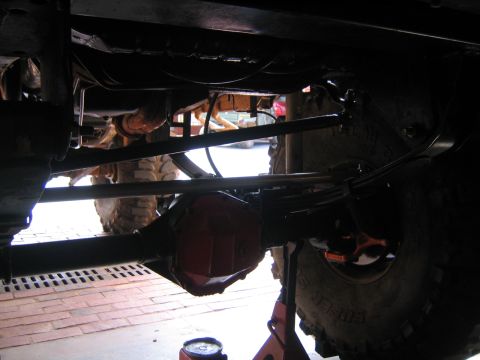 1979 Ford Bronco - The photo shows the undercarriage of a vehicle, focusing on the rear axle and suspension system during a repair or modification.