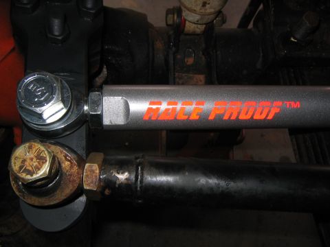 1979 Ford Bronco - Close-up of a vehicle's steering linkage, 'Race Proof' branding on a rod.