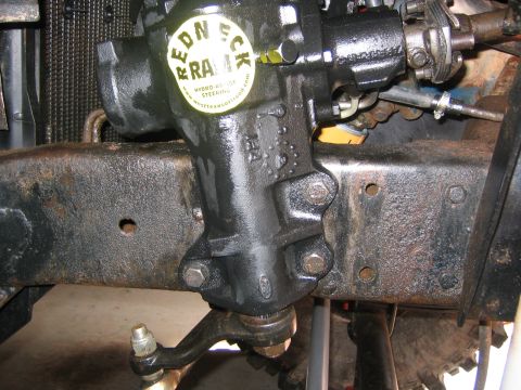 1979 Ford Bronco - Close-up of a steering box assembly on a vehicle frame, showing mechanical components and a branded sticker.
