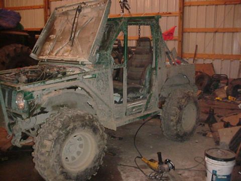 1992 Ford Bronco - This heavily modified off-road vehicle appears to be undergoing some work in a garage setting.