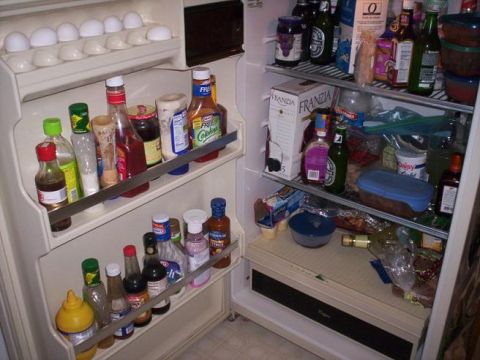 1989 Ford Bronco - A refrigerator is filled with various food items, including condiments, bottles, and eggs on the top shelf.