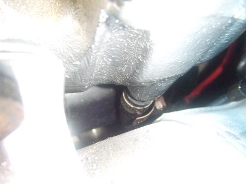 1995 Ford Mustang - Close-up view of an engine component with a clamp and a red wire visible, Supermotors.net logo in corner.