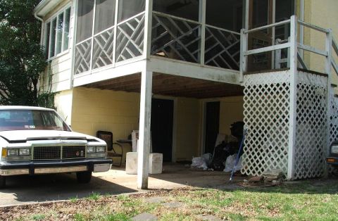 1991 Ford LTD Crown Victoria - A white sedan sits in front of a house with its hood open, revealing a prominent chrome grille.