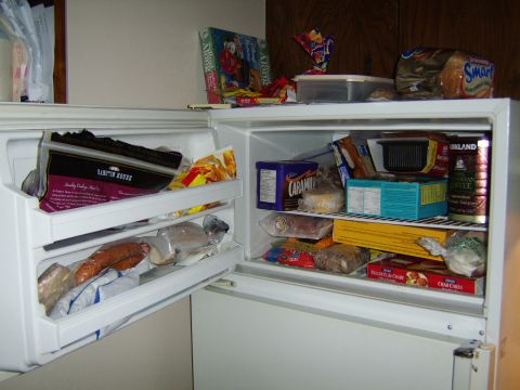 1989 Ford Bronco - The inside of a refrigerator is filled with various food items, including packaged goods and frozen foods.