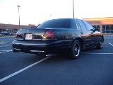 2001 Ford Crown Victoria - Rear view of a black 2001 Ford Crown Victoria parked in a lot.