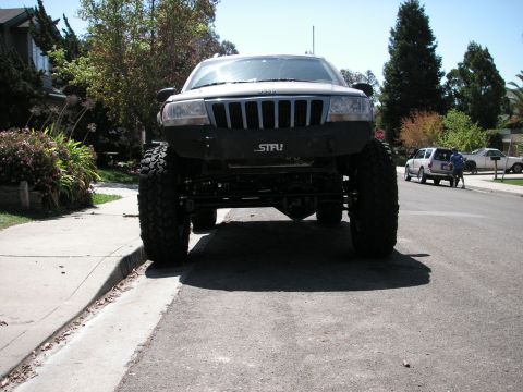 1999 Jeep Grand Cherokee - This modified 1999 Jeep Grand Cherokee features a lifted suspension, large off-road tires, and a custom front bumper.