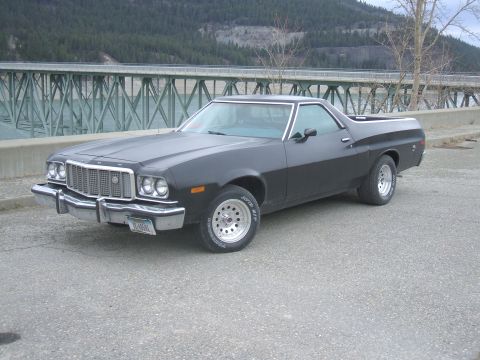 1974 Ford Ranchero - This 1974 Ford Ranchero is parked on a road with a bridge and water in the background.