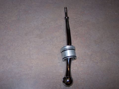 1995 Ford Probe - This chrome shift lever features a polished finish and a distinctive knob. It is presented against a textured background.