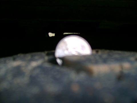 1989 Ford Bronco - A close-up view of a vehicle's wheel well, showing a bright reflection within the dark space.