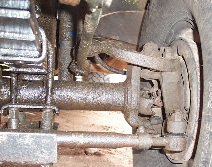 Underside view of solid front axle, radius arm, tie rod end and leaf spring