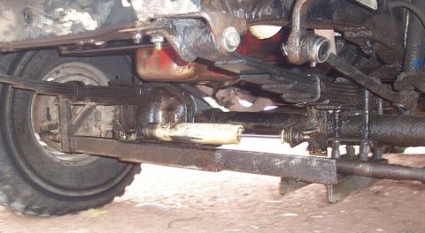 1990 Ford Bronco - Close-up of the vehicle's undercarriage, focusing on the suspension and rear axle assembly.