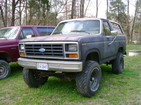 1989 Ford Bronco - This 1989 Ford Bronco is parked next to another vehicle, showing its front three-quarter view.