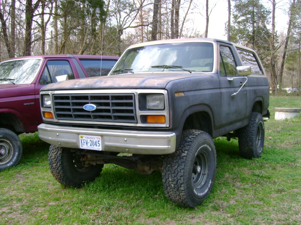 Dark blue 1989 Ford Bronco with a tan top and aftermarket wheels
