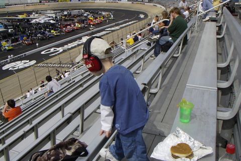 1995 Ford Bronco - A race track scene with spectators in the foreground and many cars visible on the track.