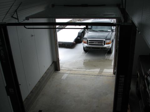 1992 Ford Bronco - A black Ford F-Series truck is parked in a garage with a trailer behind it.