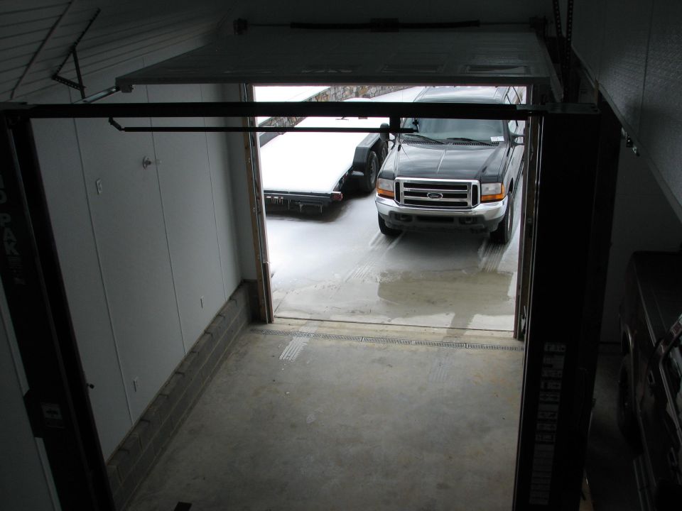 Dark gray Ford pickup seen through a garage overhead door from inside