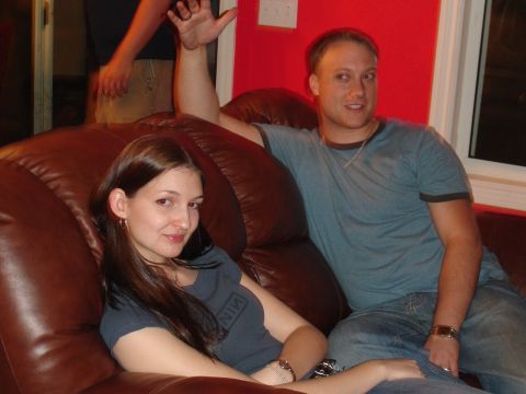 1994 Ford Probe - Two people are seen relaxing on a brown leather couch, with a third person's arm visible in the background.
