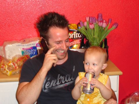 1994 Ford Probe - A man talks on his phone while a baby drinks from a can, with tulips and snacks visible.
