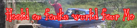 1988 Ford Bronco - A blue pickup truck sits nose-down in a muddy water crossing surrounded by trees, with a man in a red shirt standing beside it and part of…