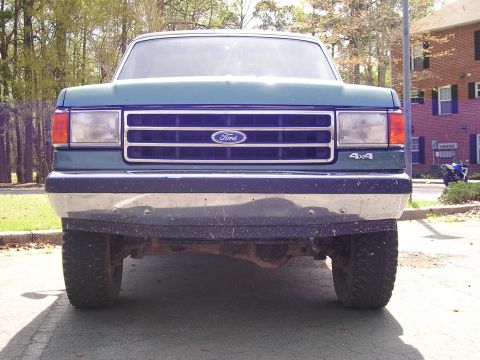 1989 Ford Bronco - This Ford truck features a prominent grille with the Ford logo and 4x4 badging on the fender.