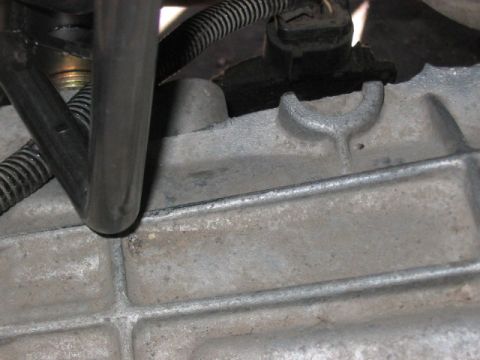 1991 Ford Bronco - Metal engine component with attached hoses and electrical wiring visible.
