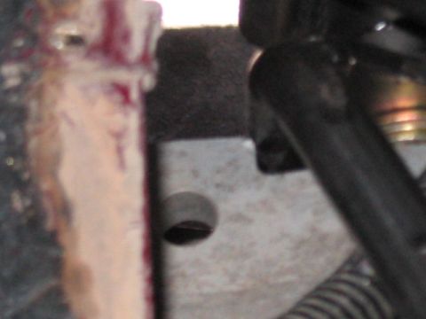 1991 Ford Bronco - A close-up view of a vehicle's mechanical components, showing a metal bracket and some surrounding parts.