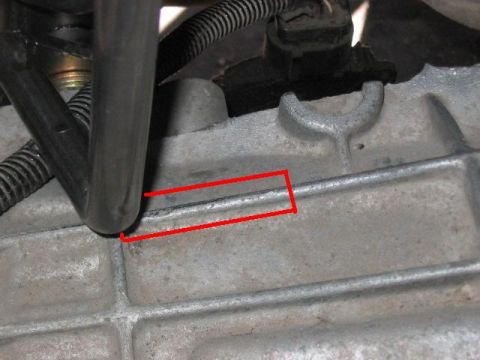 1991 Ford Bronco - A close-up view of a metal engine component, possibly part of a transmission or casing, with red lines highlighting a specific area.
