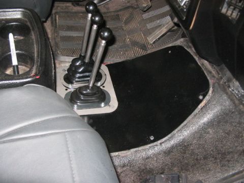 1991 Ford Bronco - Vehicle interior with a complex shifter setup and a cup holder visible.