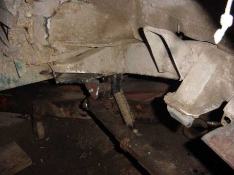 1992 Ford Bronco - Close-up view of the vehicle's frame and suspension system, showing signs of rust and custom work.