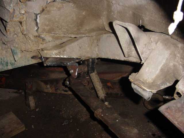 Frame and suspension components with visible rust and modifications
