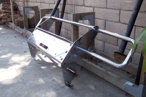 1990 Ford Bronco - A custom winch bumper is shown, likely for an off-road vehicle, resting on a concrete surface.