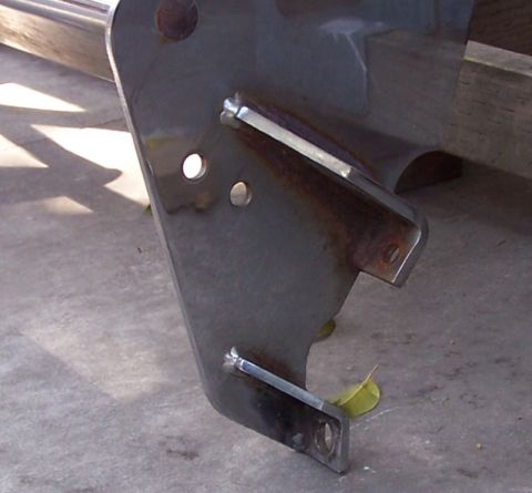 1990 Ford Bronco - A close-up view of a dark metal winch bumper bracket with welded tabs and mounting holes.