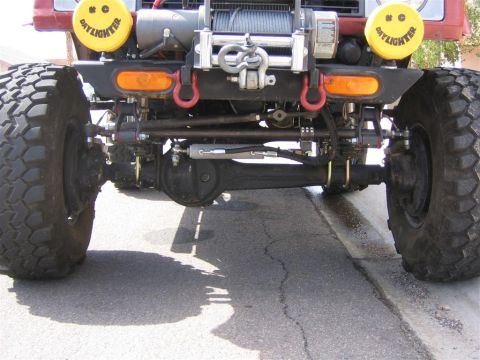 1987 Suzuki Samurai - Modified front axle and suspension components on an off-road vehicle, a winch and auxiliary lights.