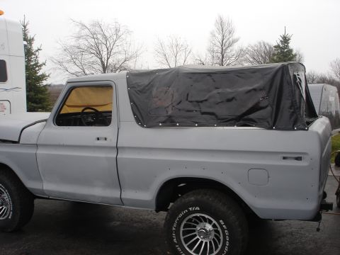 1979 Ford Bronco - This Ford Bronco appears to be undergoing restoration, with a primer gray finish and a black soft top covering the rear.