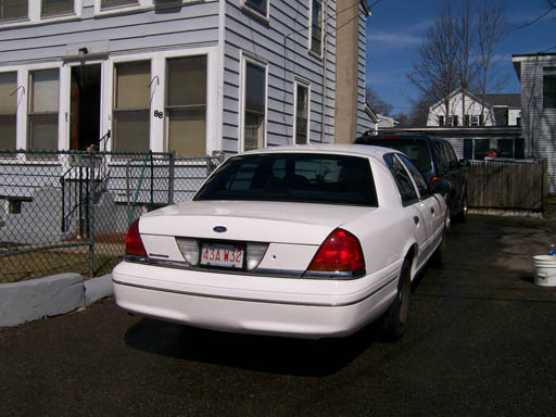 White Ford Crown Victoria, rear view, parked in driveway