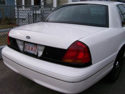 1999 Ford Crown Victoria - The rear of a white Ford Crown Victoria is shown, with a license plate reading 43A W32.